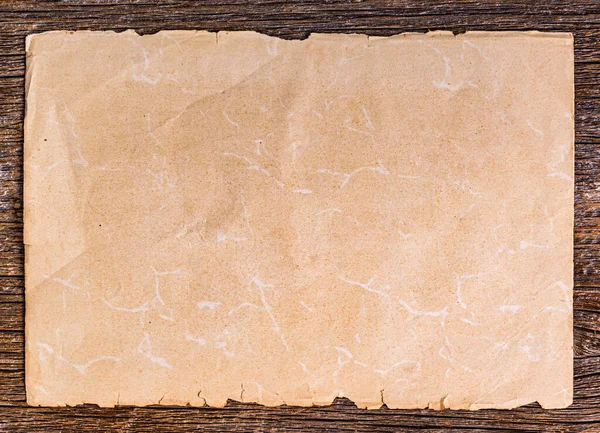 木制背景上的一张旧纸片 关于棕色老化木材 — 图库照片