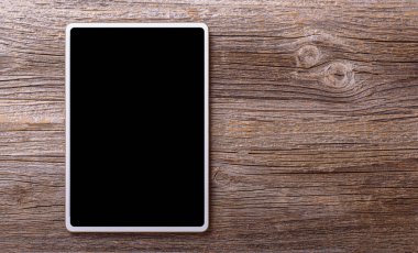 Ahşap bir arka planda beyaz tablet.