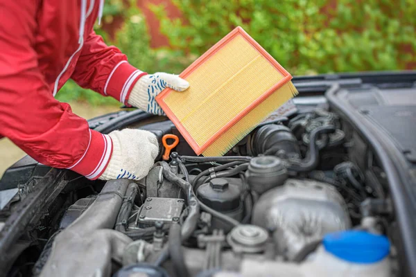 Change the air filter on the car engine during vehicle maintenance.