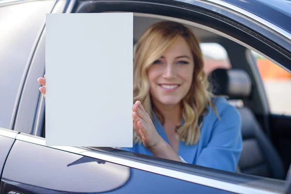 Härlig Ung Kvinna Som Håller Ett Blankt Papper Bakgrunden Bilen — Stockfoto
