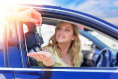 Bir kadının eli, arabanın anahtarını verir. Araba almak ya da kiralamak..