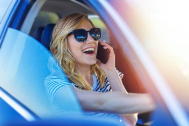 Araba sürerken akıllı telefon kullanan genç güzel kadın