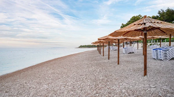 Strohschirme Mit Sonnenliegen Strand Strohschirme Und Gestapelte Liegestühle Strand Bei — Stockfoto