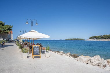 Primosten, Hırvatistan - 27 Temmuz 2023: Primosten 'de teraslı restoran, eski kent mimarisi. Dalmaçya, Hırvatistan.