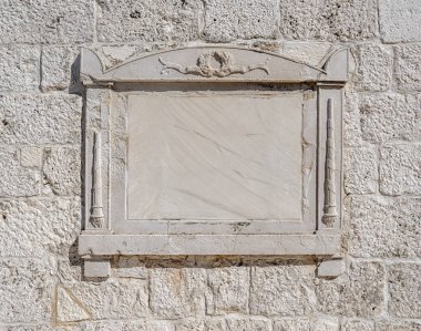 Eski bir binanın duvarında taş tablet var..