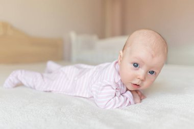 Küçük bir bebek iyi bir ruh hali. Bebek kız yatakta yatıyordu.