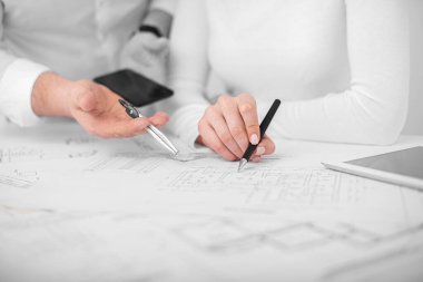 Ofisteki mühendisler proje çizimleri üzerinde görüşüyorlar..