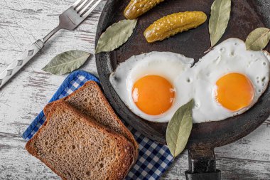 Kızarmış tavada yumurta ve salatalık turşusu..