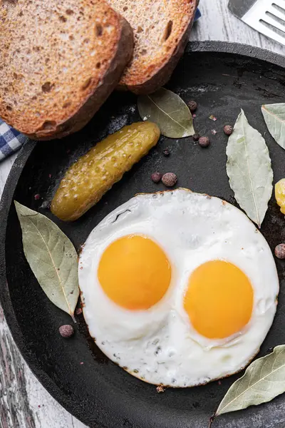 Kızarmış tavada yumurta ve salatalık turşusu..