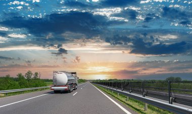 Otobanda beyaz bir kamyon var. Beyaz kamyon asfalt yolda..