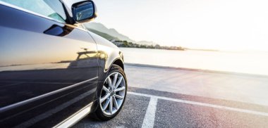 Araba gün batımında denizin arka planına parkedilmiş..