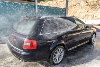 Açık gökyüzünün altında araba yıkama. Dışarıda yüksek basınçlı araba yıkama.