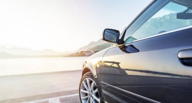 Araba gün batımında denizin arka planına parkedilmiş..