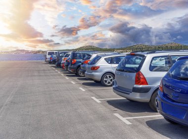Araba parkı. Arabalar bir göletin yakınındaki asfalt bir otoparkta park halindeler..