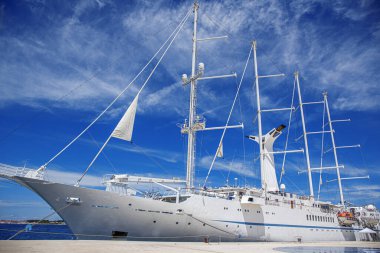 Limanda yelkenleri indirilmiş beyaz yelkenli gemi..