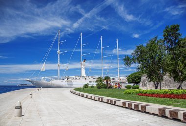 Limanda yelkenleri indirilmiş beyaz yelkenli gemi..