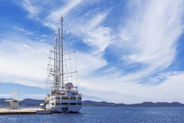 Limanda yelkenleri indirilmiş beyaz yelkenli gemi..