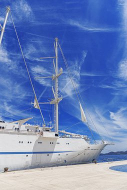 Limanda yelkenleri indirilmiş beyaz yelkenli gemi..