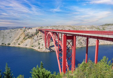 Dağların arka planında bir yolu olan demir kemer köprüsü..