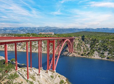 Dağların arka planında bir yolu olan demir kemer köprüsü..