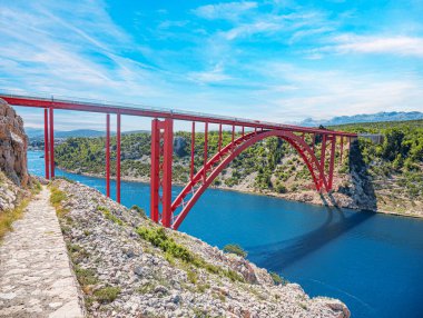 Dağların arka planında bir yolu olan demir kemer köprüsü..