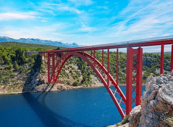 Dağların arka planında bir yolu olan demir kemer köprüsü..