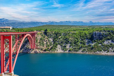 Dağların arka planında bir yolu olan demir kemer köprüsü..