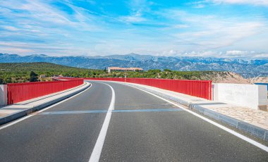 Dağların arka planında bir yolu olan demir kemer köprüsü..