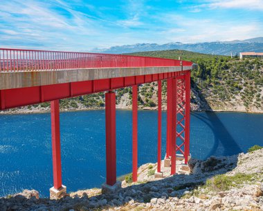 Dağların arka planında bir yolu olan demir kemer köprüsü..