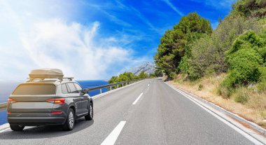 Seyahat arabası güneşli bir yaz gününde deniz kıyısı boyunca sürer..