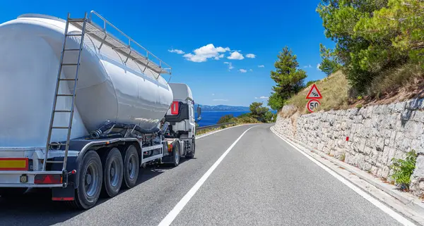 Yakıt kamyonu güzel bir yolda. Beyaz bir tank kamyonu yakıt taşıyor..