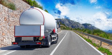 Yakıt kamyonu güzel bir yolda. Beyaz bir tank kamyonu yakıt taşıyor..