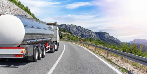 Yakıt kamyonu güzel bir yolda. Beyaz bir tank kamyonu yakıt taşıyor..