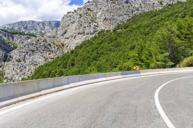 Arka planda kayalık dağlar olan köy yolu..