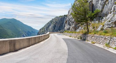 Arka planda kayalık dağlar olan köy yolu..