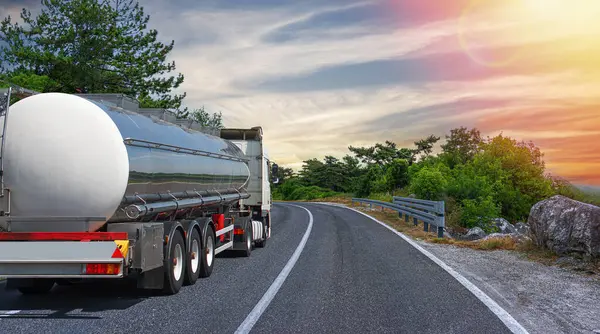 油罐车停在风景如画的路上 一辆银色罐车运送燃料 免版税图库图片