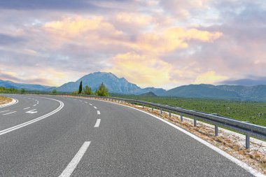 Arka planda kayalık dağlar olan köy yolu..