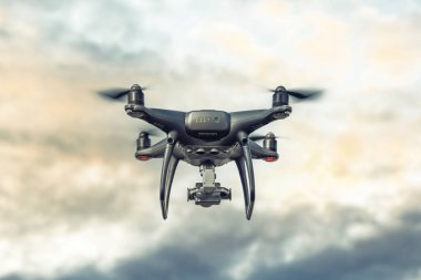 Kameralı modern drone gökyüzünde uçuyor..