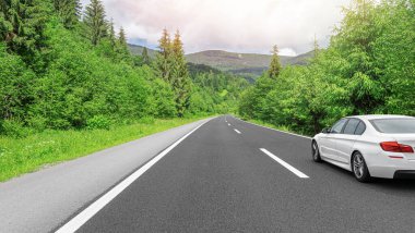 Orman yolunda bir araba koşturuyor..