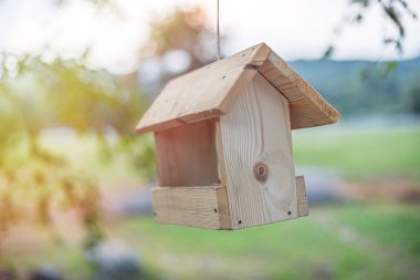 Ağaç dalları üzerinde ahşap kuş evi.