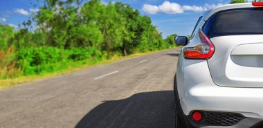 Bir otoyolun kenarına beyaz bir araba park edilmiş..