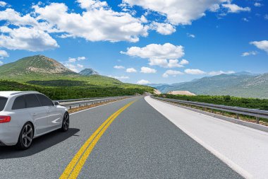 Araba otoban boyunca sürüyor. Etrafı resimlerle çevrili..