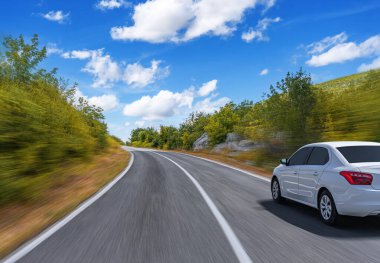 Araba otoban boyunca sürüyor. Etrafı resimlerle çevrili..