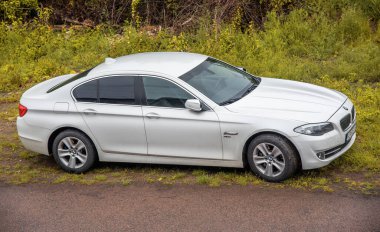 Beyaz BMW xDrive yolun kenarına park edilmiş..