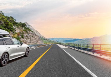 Araba otoban boyunca sürüyor. Etrafı resimlerle çevrili..