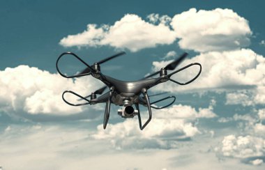 Kameralı modern drone gökyüzünde uçuyor..