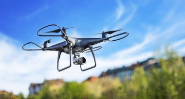Kameralı modern drone gökyüzünde uçuyor..