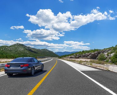 Araba otoban boyunca sürüyor. Etrafı resimlerle çevrili..