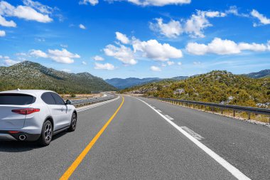 Araba otoban boyunca sürüyor. Etrafı resimlerle çevrili..