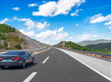 Araba otoban boyunca sürüyor. Etrafı resimlerle çevrili..